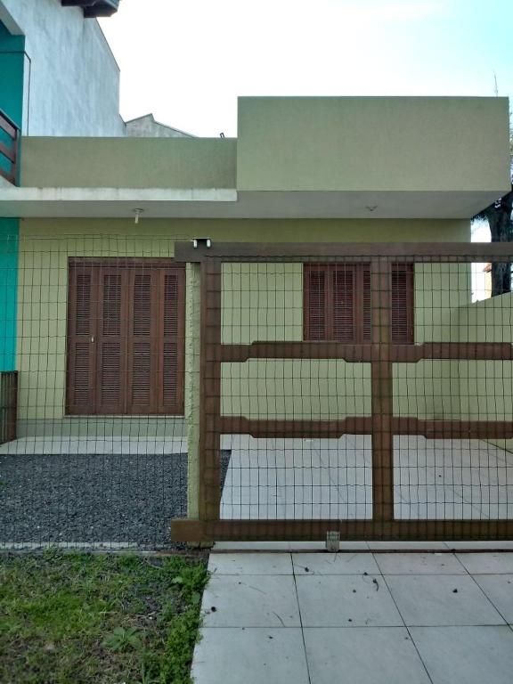 a house with a fence in front of it at Casa - Marcelo da Silva Américo in Imbé