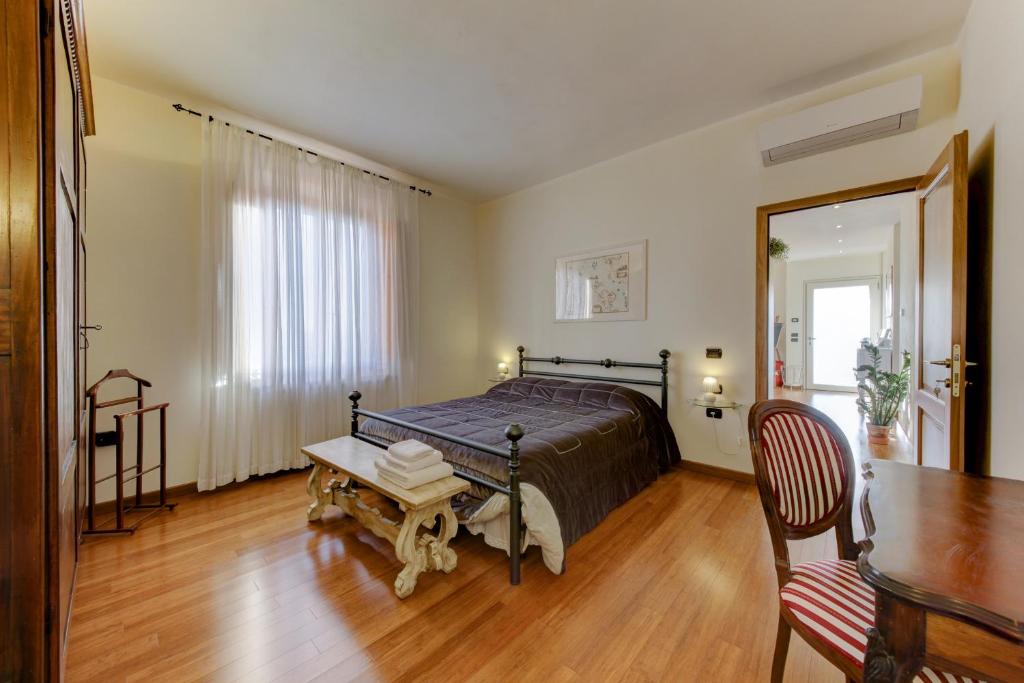 um quarto com uma cama, uma mesa e uma cadeira em B&B Il Ramaiolo em Santa Maria a Monte