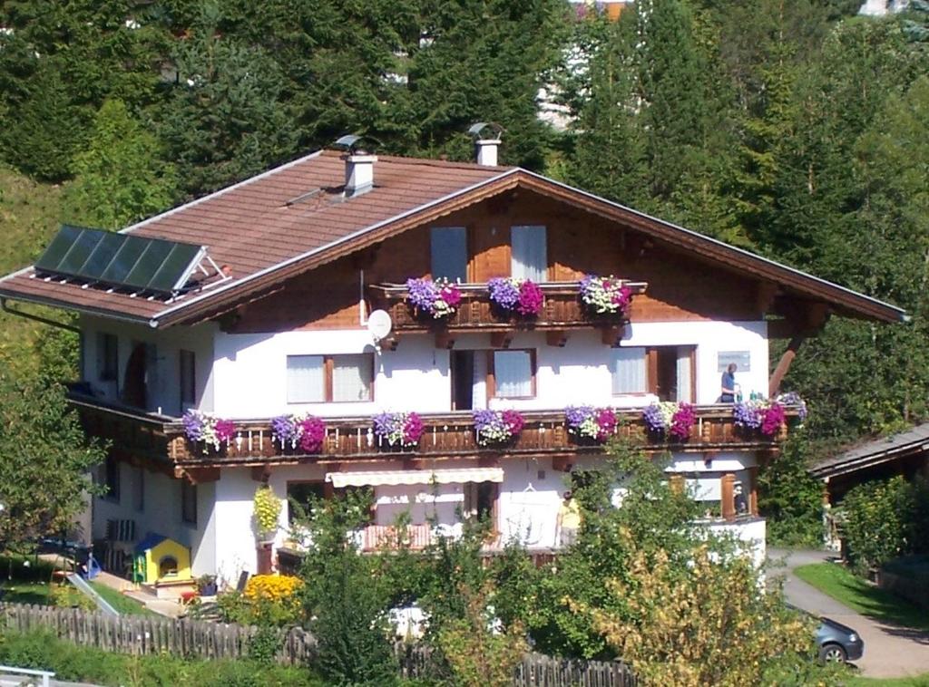 a house with a balcony with flowers on it at Haus Bergwelt in Lermoos