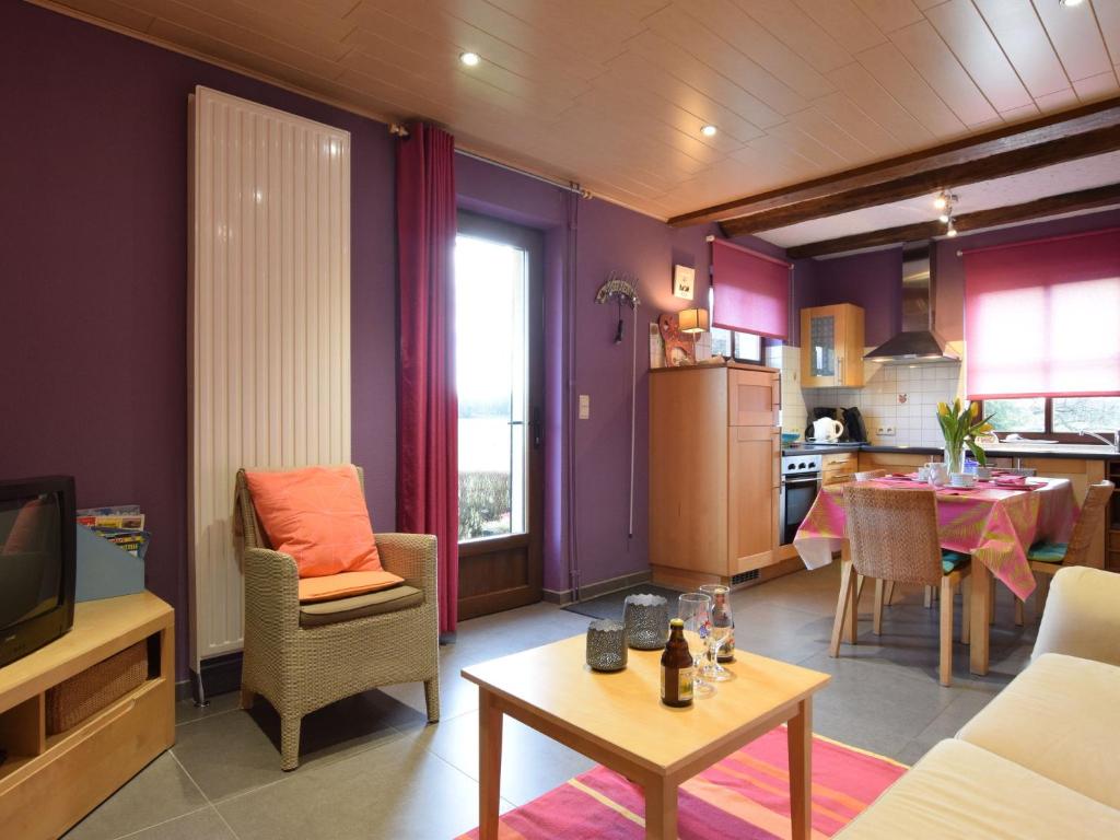 a living room with purple walls and a kitchen at Peaceful Cottage in Ardennes with Private Terrace in Bastogne