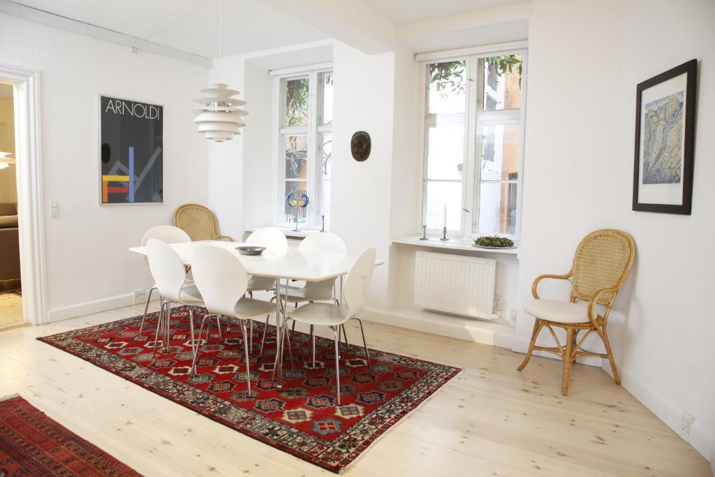 - une salle à manger blanche avec une table et des chaises blanches dans l'établissement CopenhagenApartment, à Copenhague