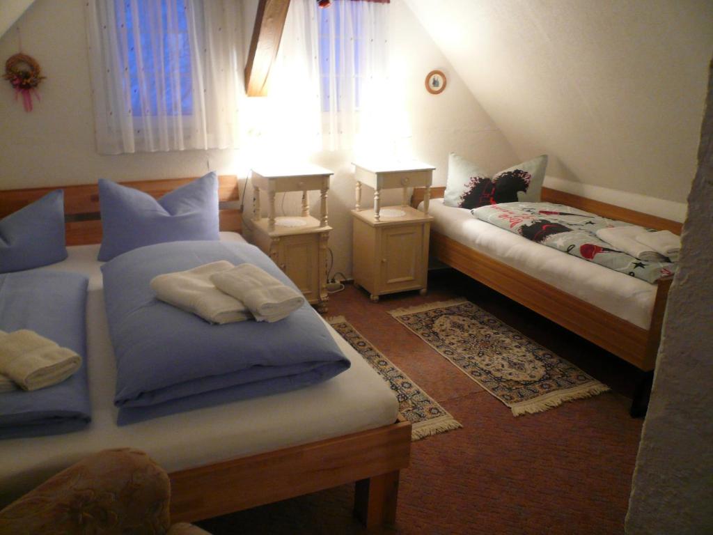 sypialnia z 2 łóżkami i stołem z lampką w obiekcie Adventure House (Abenteuerferienhaus) w mieście Rechenberg-Bienenmühle
