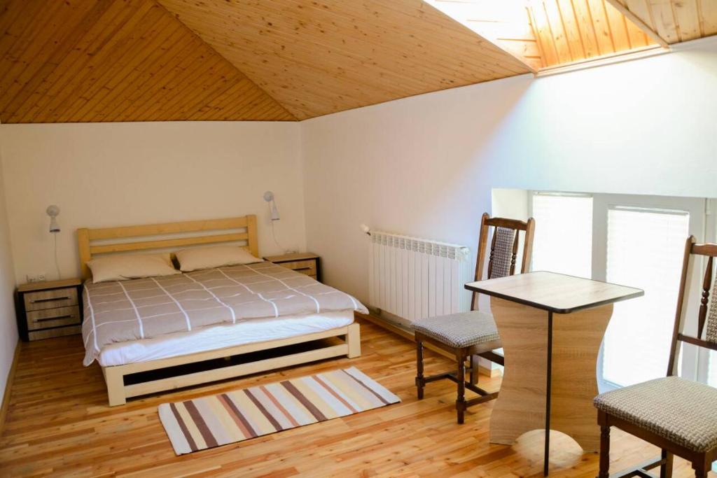 1 dormitorio con 1 cama, mesa y sillas en Котедж "Relax", en Mykulychyn