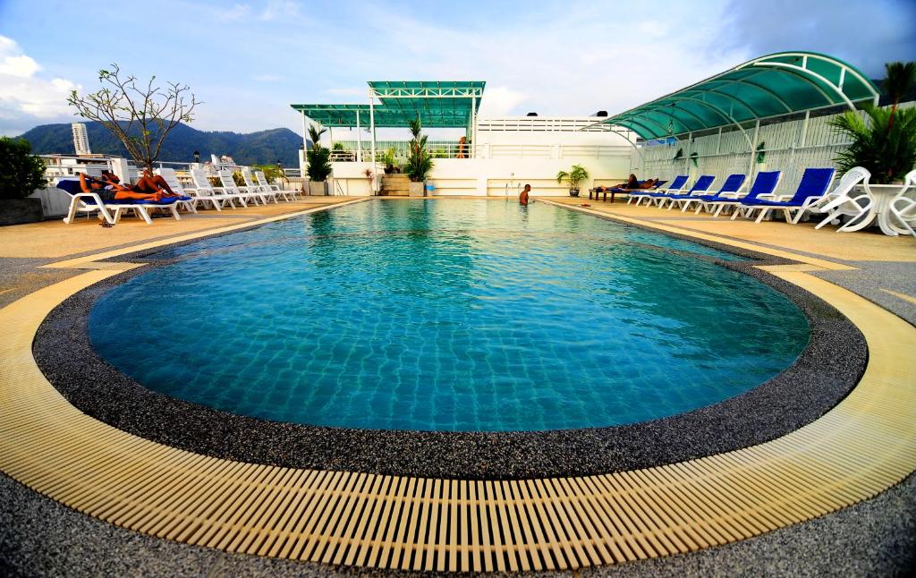 a pool on a cruise ship with chairs and a building at Arita Hotel Patong in Patong Beach