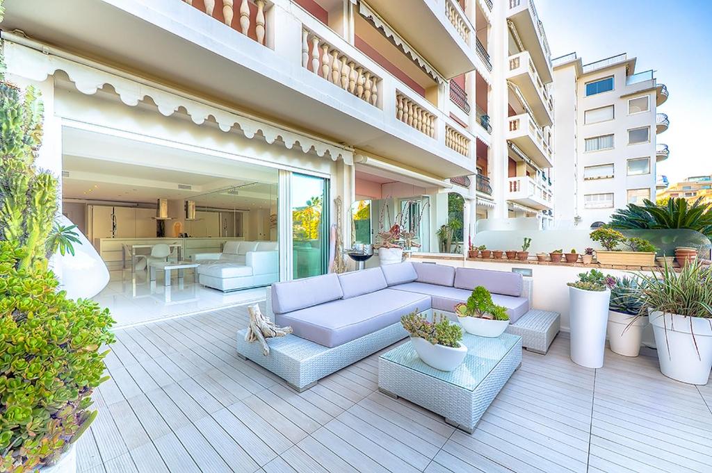 un patio con un sofá blanco y algunas plantas en Appartement l'Age d'Or, en Cannes