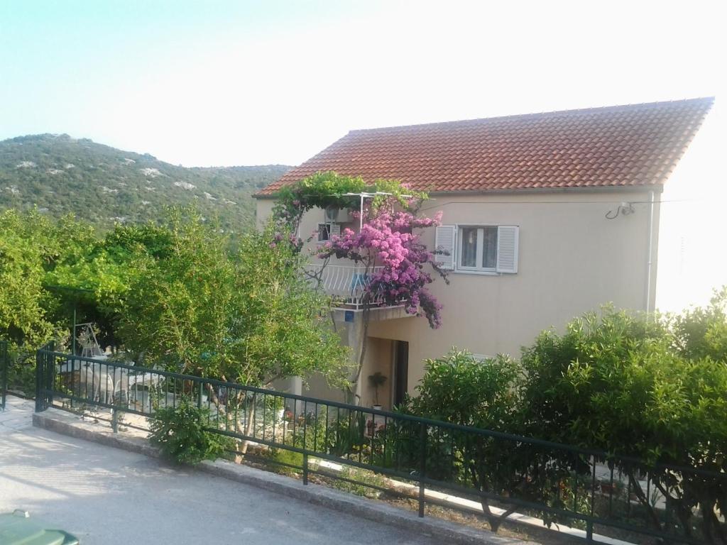 a house with a balcony with flowers on it at Apartments Jelić in Banići
