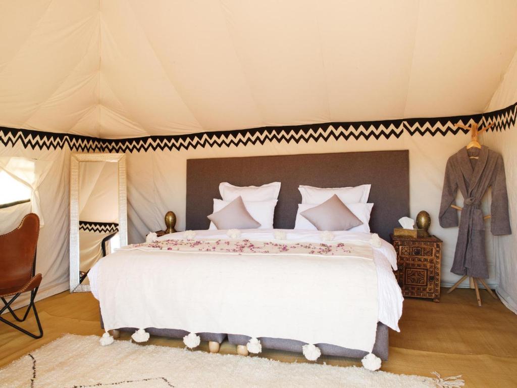 a bedroom with a large bed in a tent at Nubia Luxury Camp Erg Chegaga in El Gouera