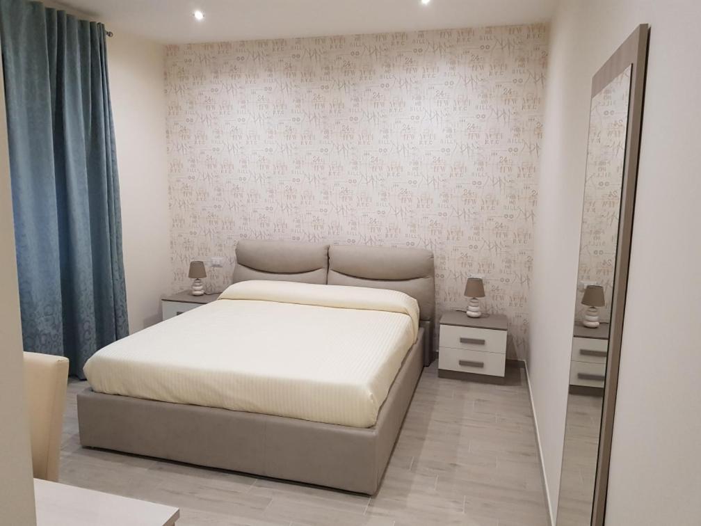カッシーノにあるLa Suiteの白いベッドルーム(ベッド1台、鏡付)