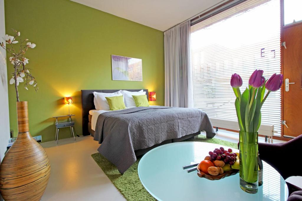 アムステルダムにあるイースタンドロームのベッドルーム1室(ベッド1台、花のテーブル付)