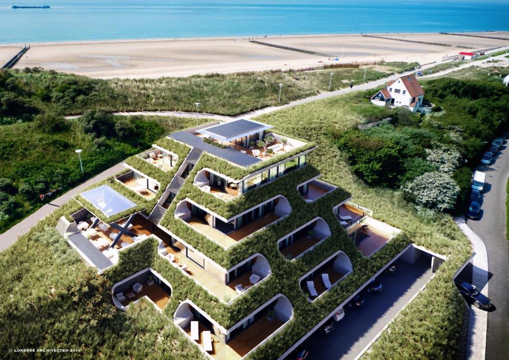 une vue aérienne sur une maison avec un toit vert dans l'établissement Duinhotel Tien Torens, à Zoutelande