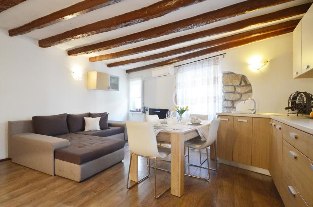 a kitchen and living room with a table and a couch at Apartment Eleni in Rovinj
