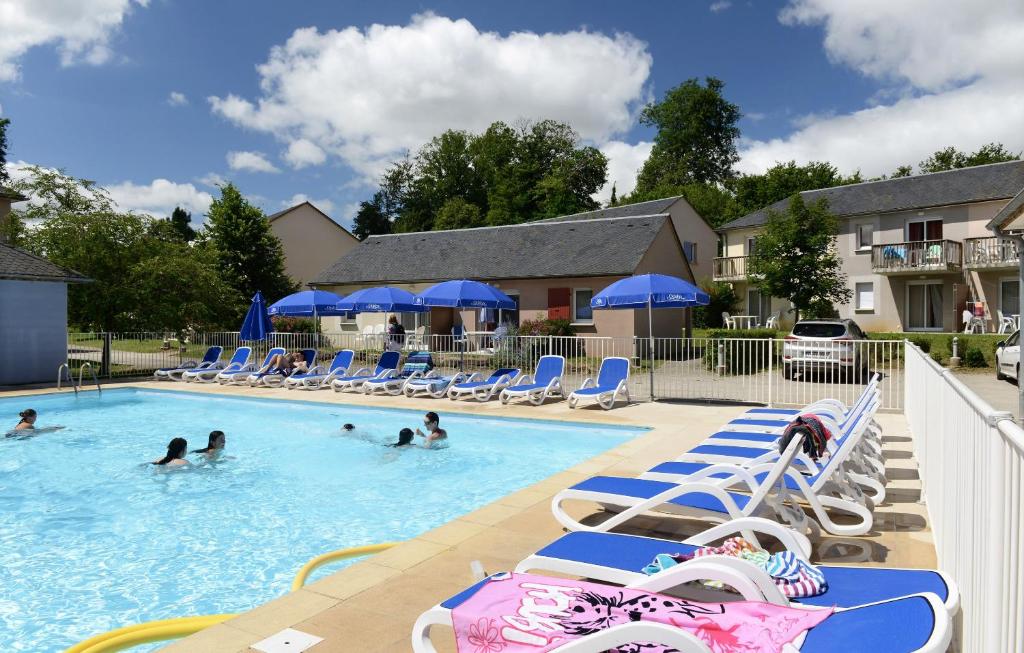 a group of people swimming in a swimming pool at Résidence Odalys Le Hameau du Lac in Rignac