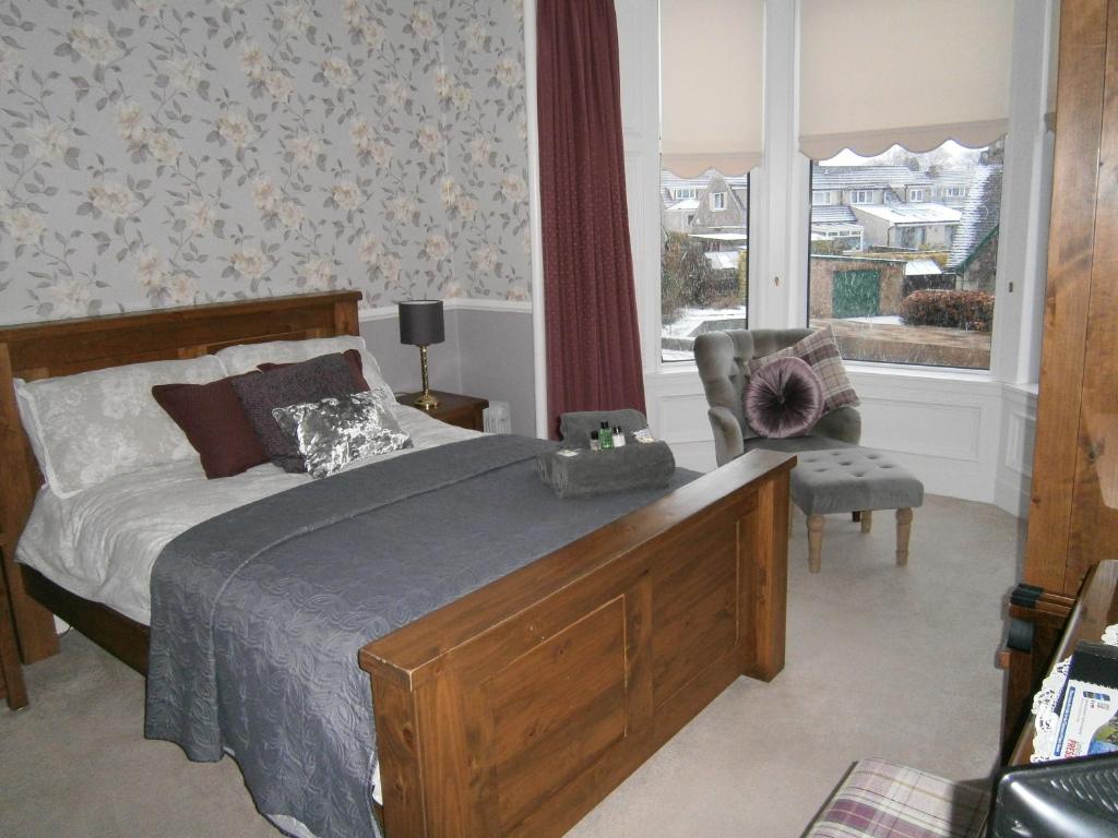 a bedroom with a bed and a chair and a window at Arisaig Guest House in Perth