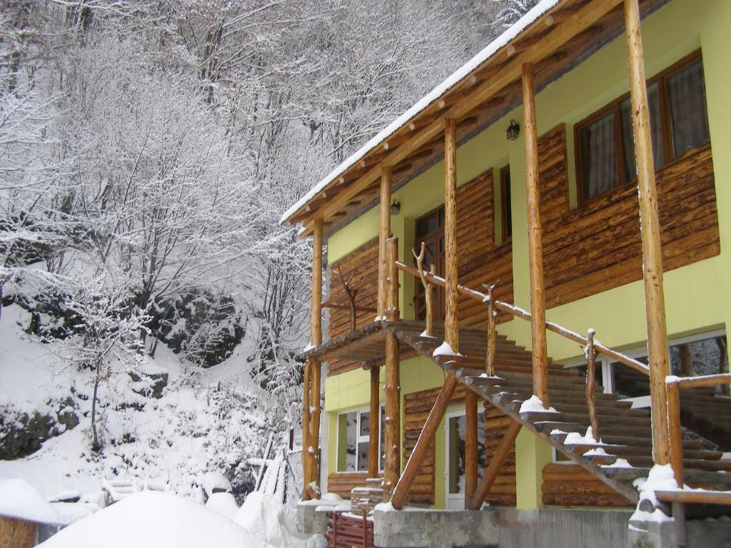 a log cabin in the snow with snow covered trees at El Stefano Srl in Cavnic