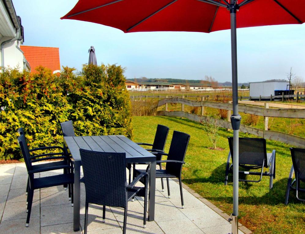 a table and chairs with an umbrella on a patio at Ferien_HAUS FOHLENWEIDE in Göhren-Lebbin