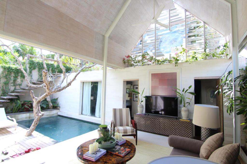 una sala de estar con piscina y una villa en Kawung Villa, en Canggu