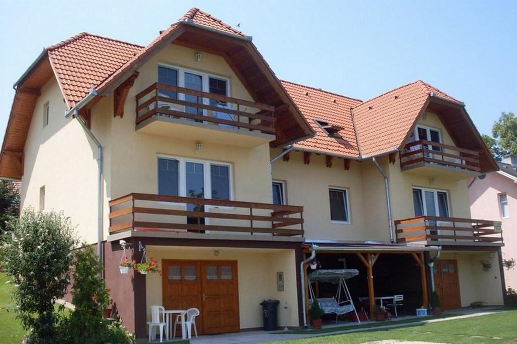 una grande casa con un balcone sopra di Lala Apartmanok a Balatonboglár