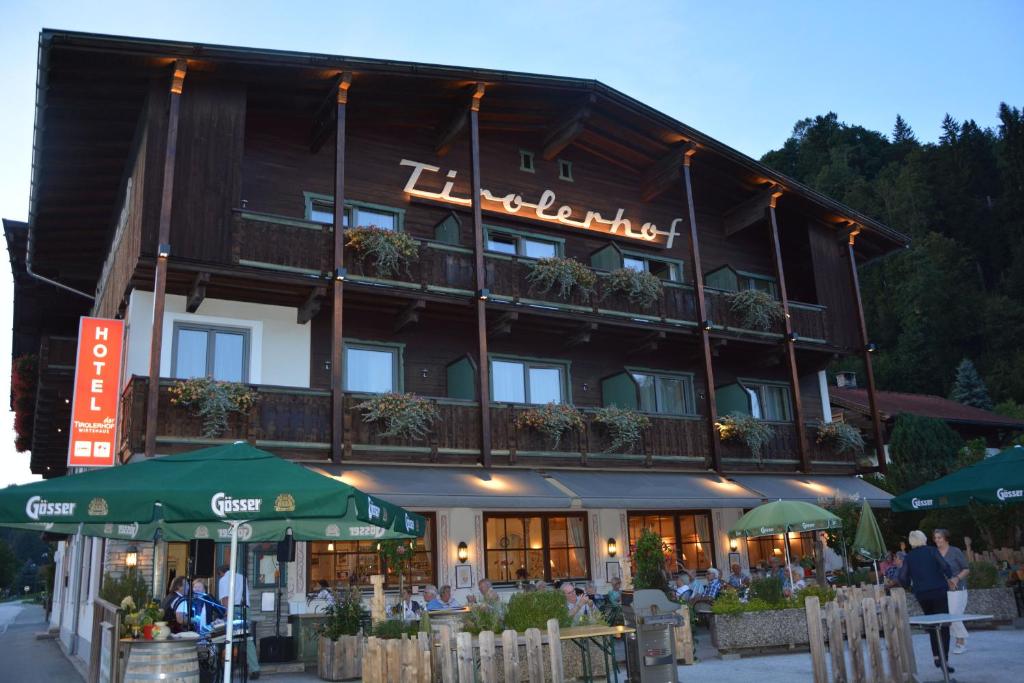 ein Hotel mit Leuten, die vor dem Hotel an Tischen sitzen in der Unterkunft Hotel Garni Tirolerhof in Hopfgarten im Brixental