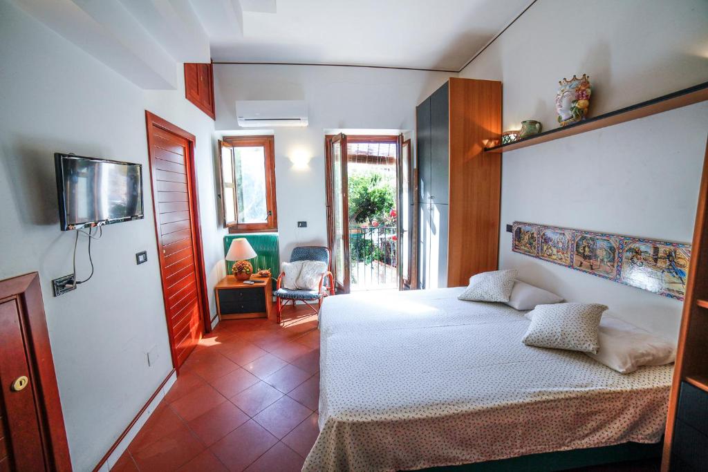 a bedroom with a white bed and a room with a chair at Il Carretto Taormina Center in Taormina