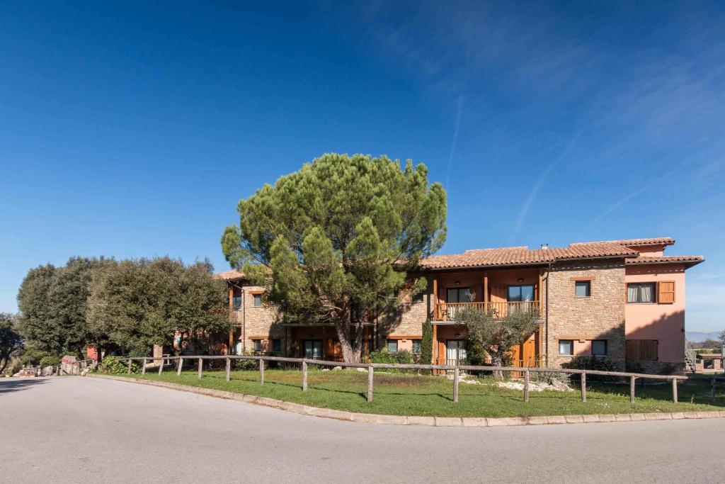 una casa con un árbol al lado de una carretera en Hotel Seva, en Seva