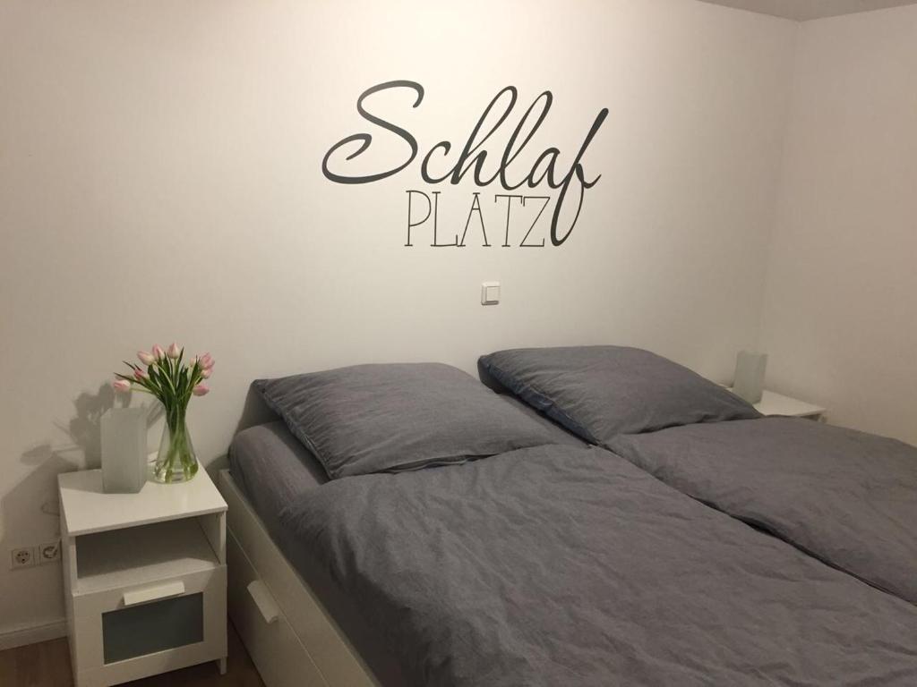 ein Schlafzimmer mit einem Bett mit einem Schild an der Wand in der Unterkunft Ferienhaus Kluntje in Emden