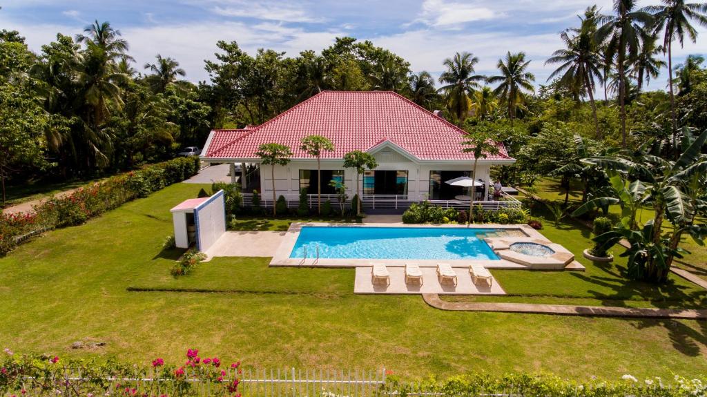 una casa con piscina en un patio en Bohol White House Bed & Breakfast, en Lila