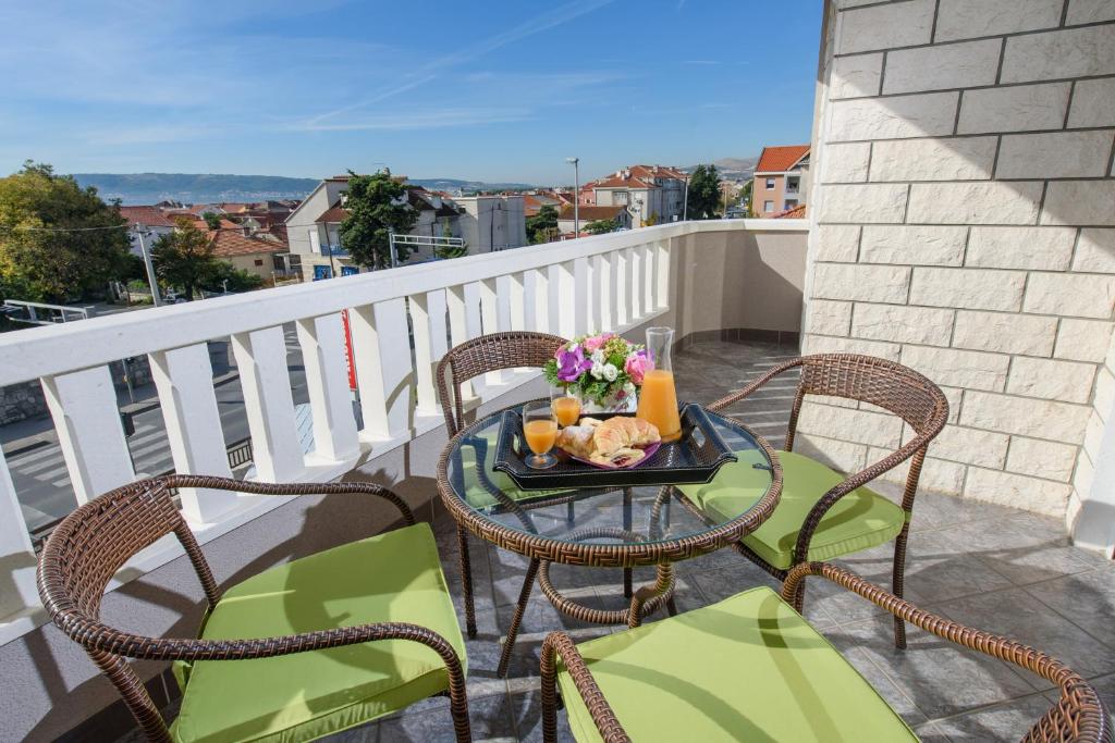stół z tacą z jedzeniem na balkonie w obiekcie Apartments Lovric with sea view w mieście Kaštela