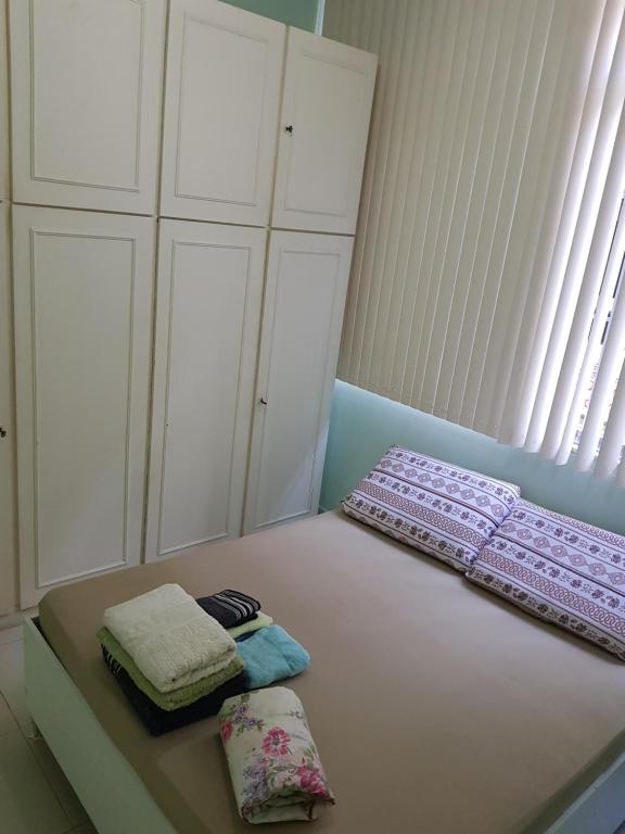 a bedroom with white cabinets and two towels on a bed at Apartamento Santa Clara 86 in Rio de Janeiro