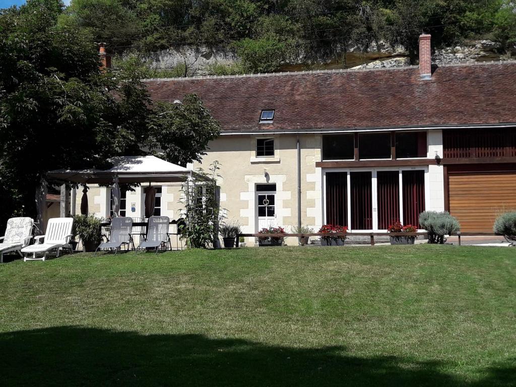 a house with chairs and a gazebo in a yard at La maison des caves in Châteauvieux