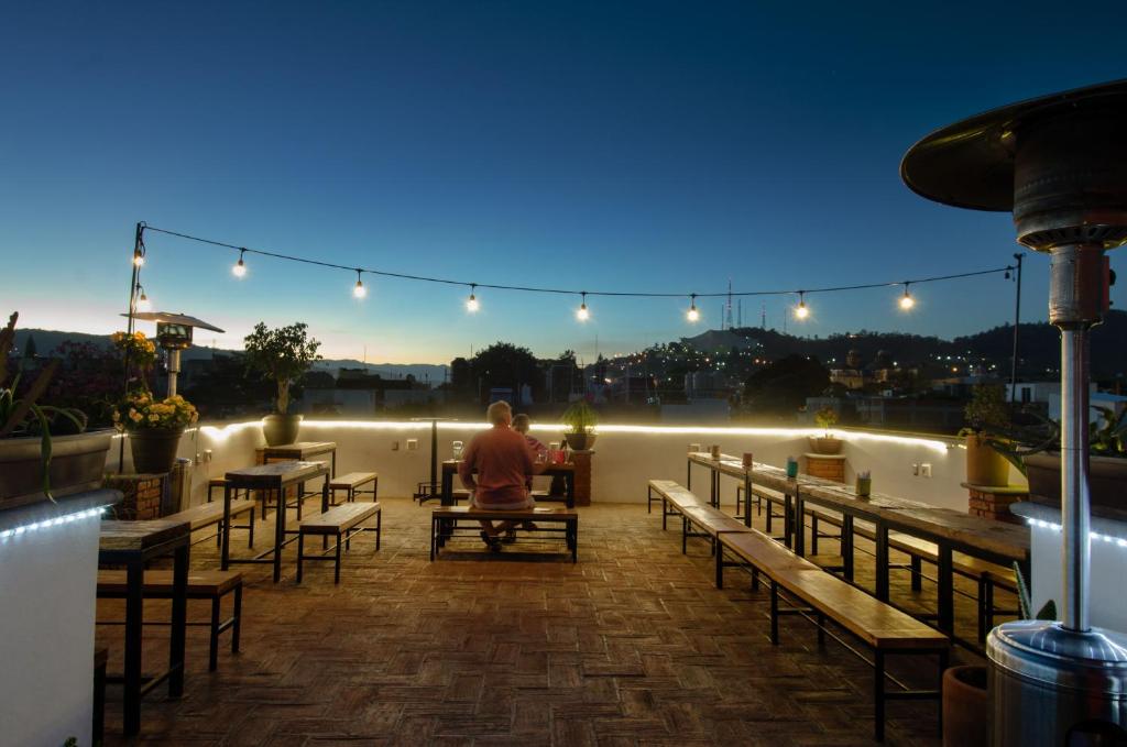 a man sitting on a rooftop patio at night at Comala Bed & Breakfast in Oaxaca City