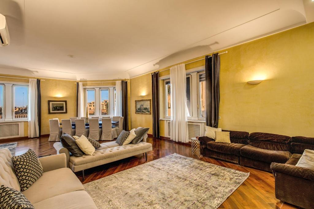 a living room with couches and chairs and windows at Imperial Panorama Penthouse in Rome