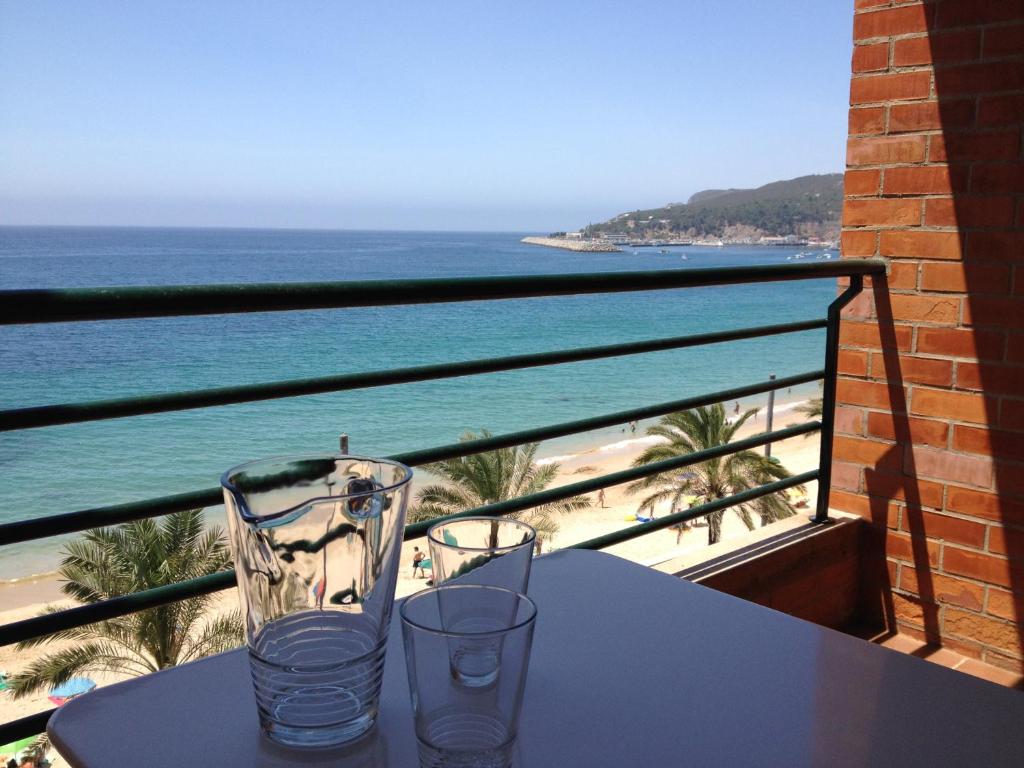 einen Tisch mit zwei Gläsern auf einem Balkon mit Strand in der Unterkunft Casa S. José in Sesimbra