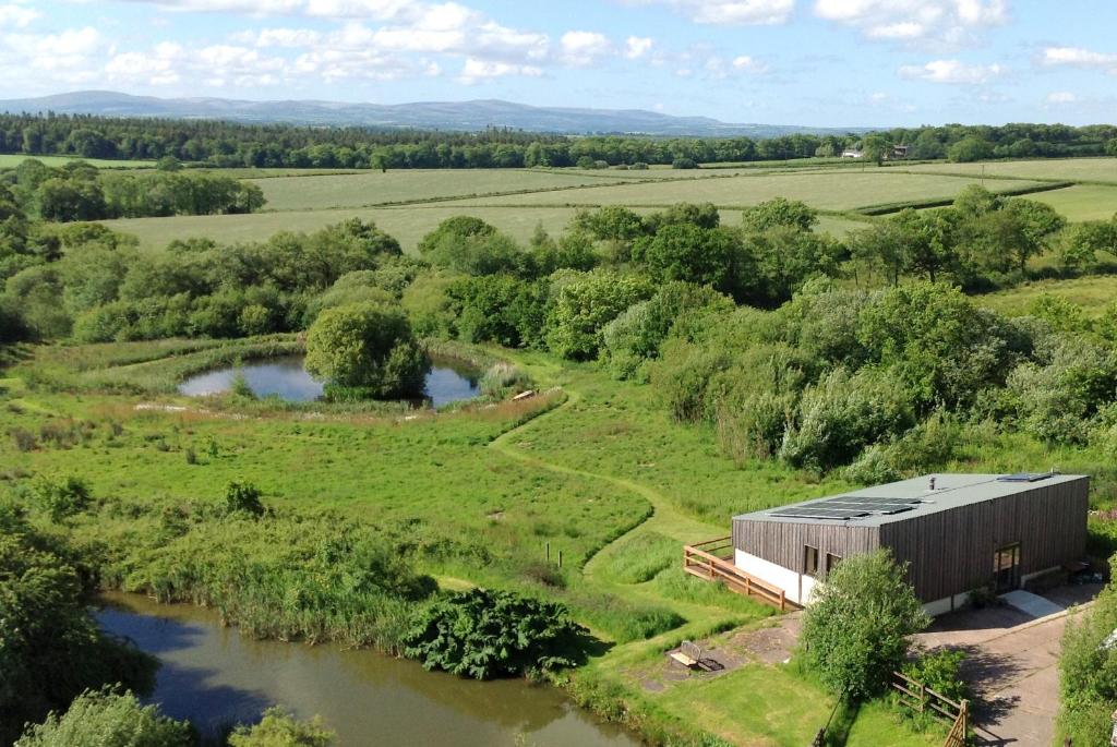 an aerial view of a barn next to a river at Devon Eco Lodges in Winkleigh
