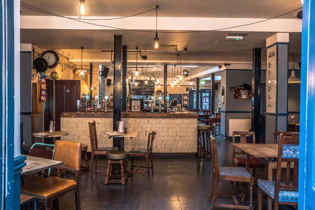 un ristorante con tavoli e sedie e un bar di Old Ship Inn Hackney a Londra