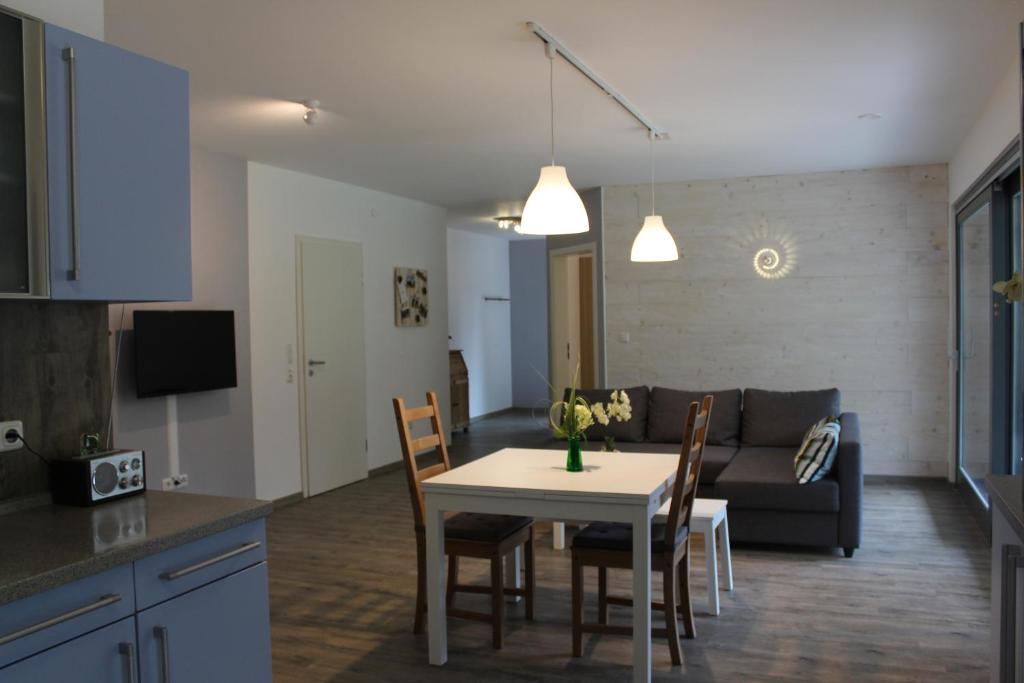 una cucina e un soggiorno con un tavolo e un divano di Ferienwohnung in der Rhön Sitzmann a Bischofsheim an der Rhön