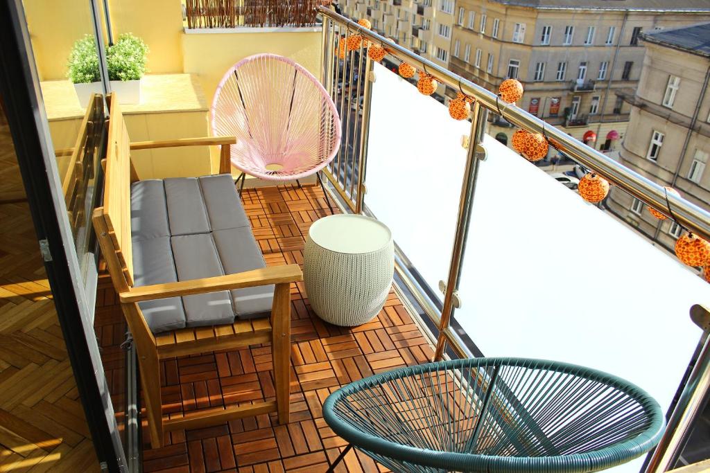 un balcon avec des chaises, une table et un ventilateur dans l'établissement WSTApartments Sunset View Krucza 46, à Varsovie