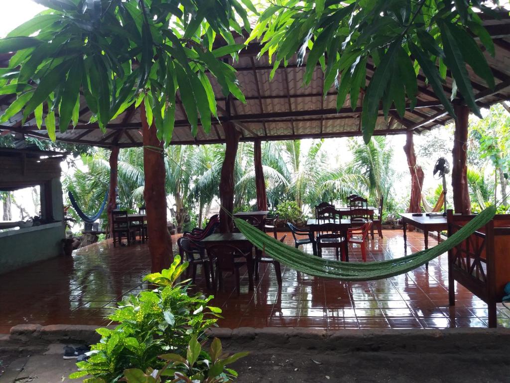 een patio met tafels en stoelen en een hangmat bij Hostal La Gloria in Mérida