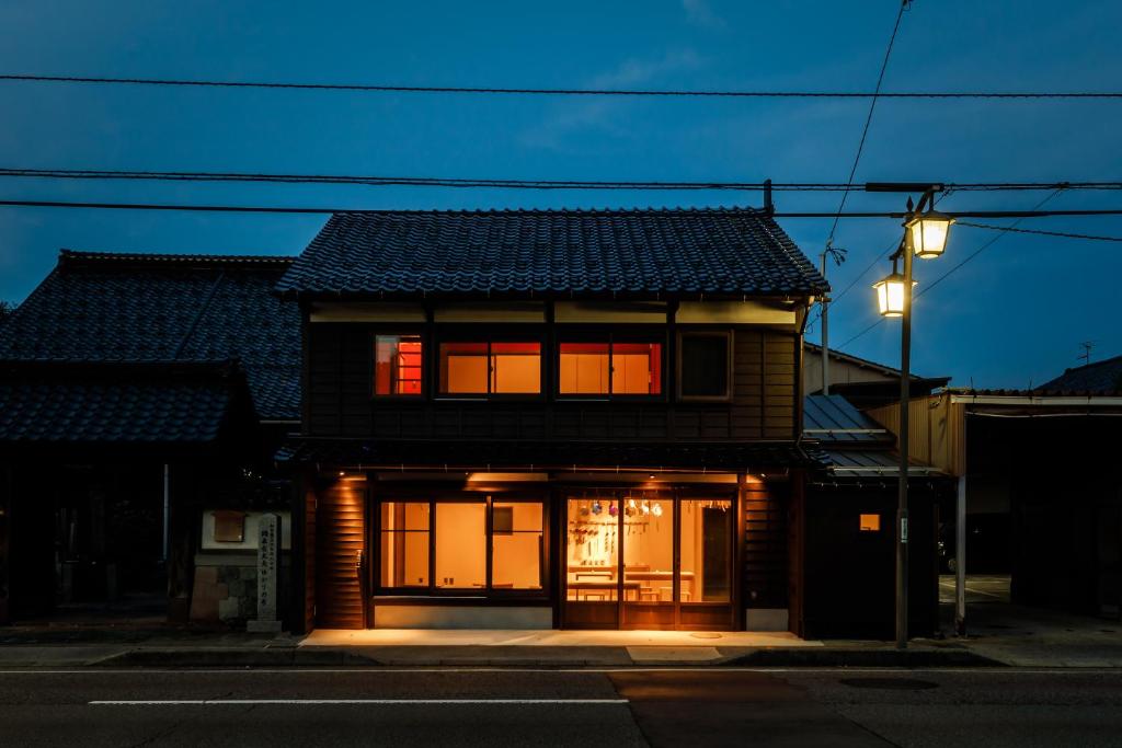 una casa con una puerta abierta en una calle en Teramachiya Wind Bell Temple Guest House, en Kanazawa