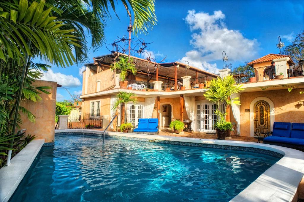 a swimming pool in front of a house at Little Arches Boutique Hotel - Adults Only in Christ Church