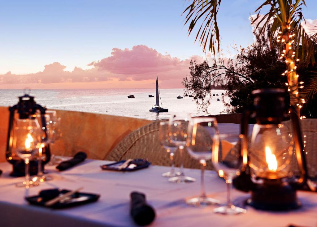 a table with wine glasses and a view of the ocean at Little Arches Boutique Hotel - Adults Only in Christ Church