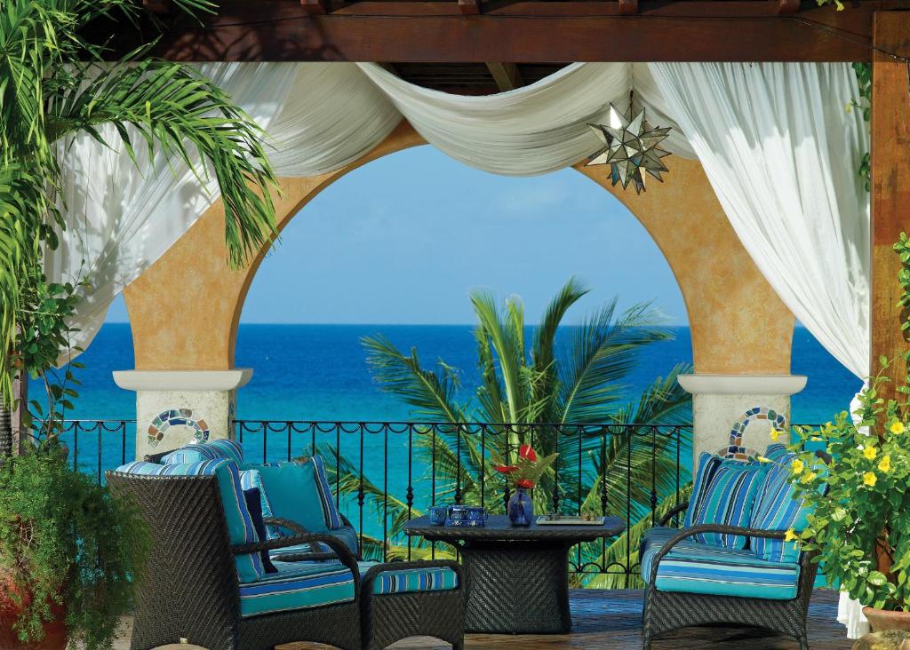 a patio with chairs and a view of the ocean at Little Arches Boutique Hotel - Adults Only in Christ Church