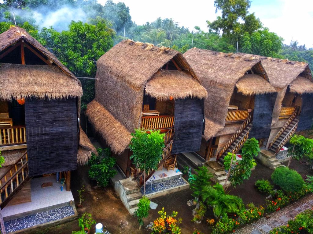 a group of houses with thatched roofs at Old Village Gili Air in Gili Islands
