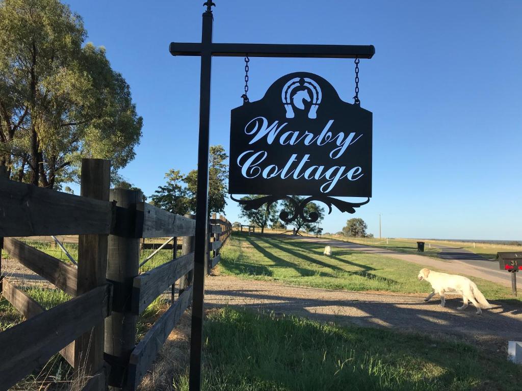 una señal para un pueblo de monos en un camino rural en Warby Cottage en Wangaratta