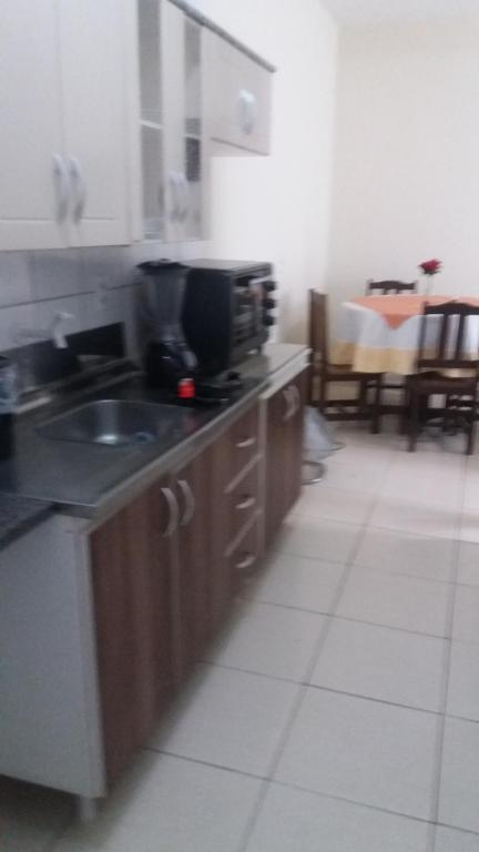 a kitchen with a sink and a counter top at Apartamento - Anthurium in Joinville
