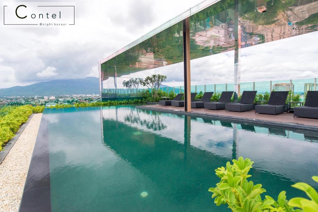 a swimming pool in front of a building at The Astra Condo Chiang Mai - A624 in Chiang Mai