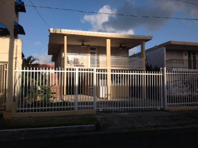 a white fence in front of a house at Luquillo Beach Getaway in Luquillo