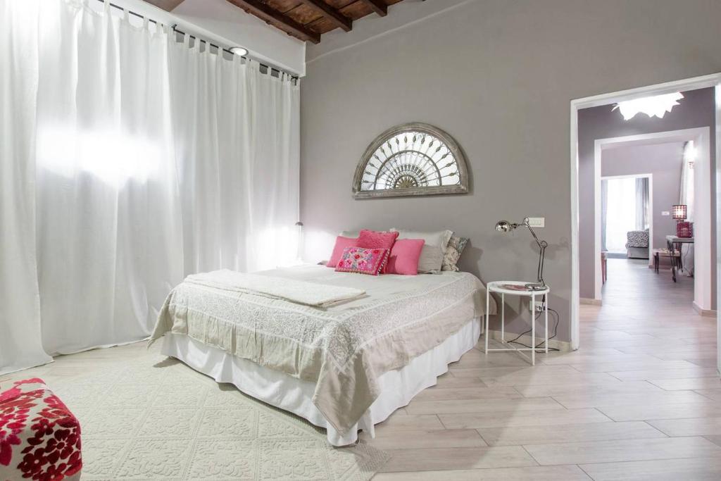 ローマにあるFarnese Suitesの白いベッドルーム(ピンクの枕が付いた大型ベッド付)