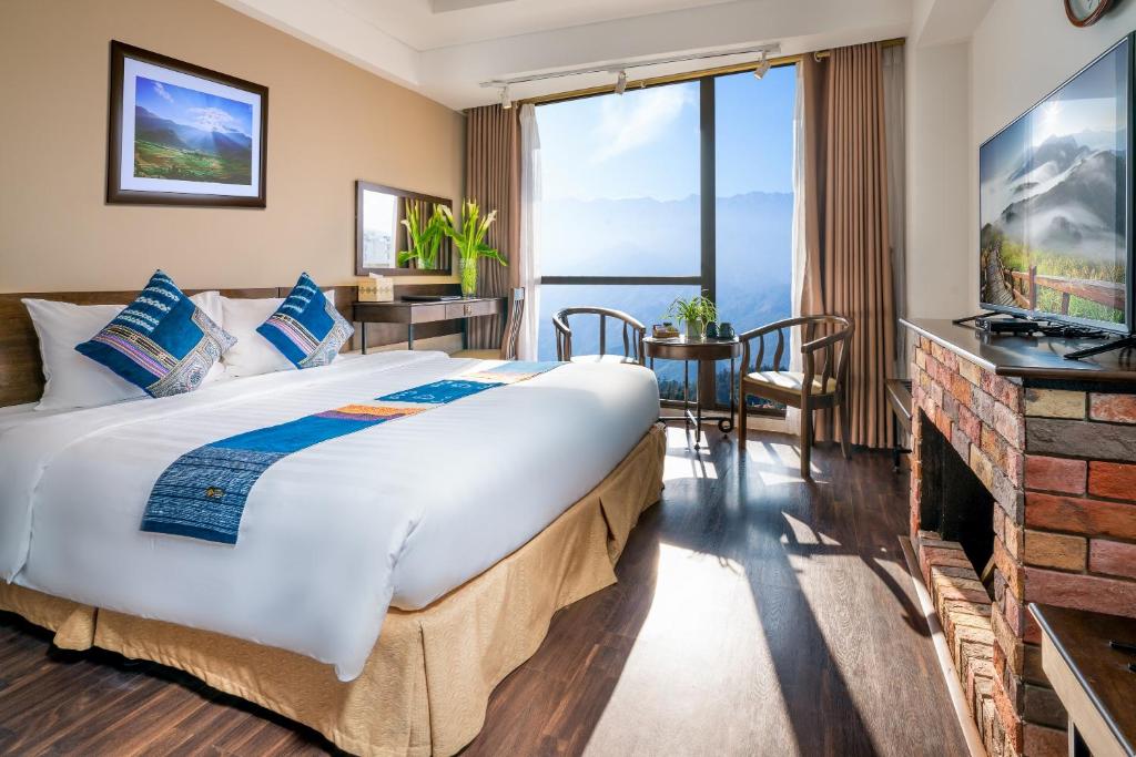 ein Hotelzimmer mit einem großen Bett und einem Kamin in der Unterkunft Amazing Hotel Sapa in Sa Pa