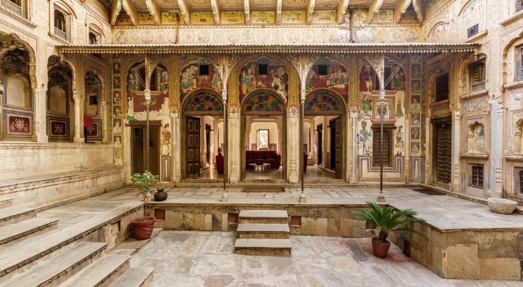 un grand bâtiment avec des escaliers et des peintures sur les murs. dans l'établissement Vivaana, à Mandāwa