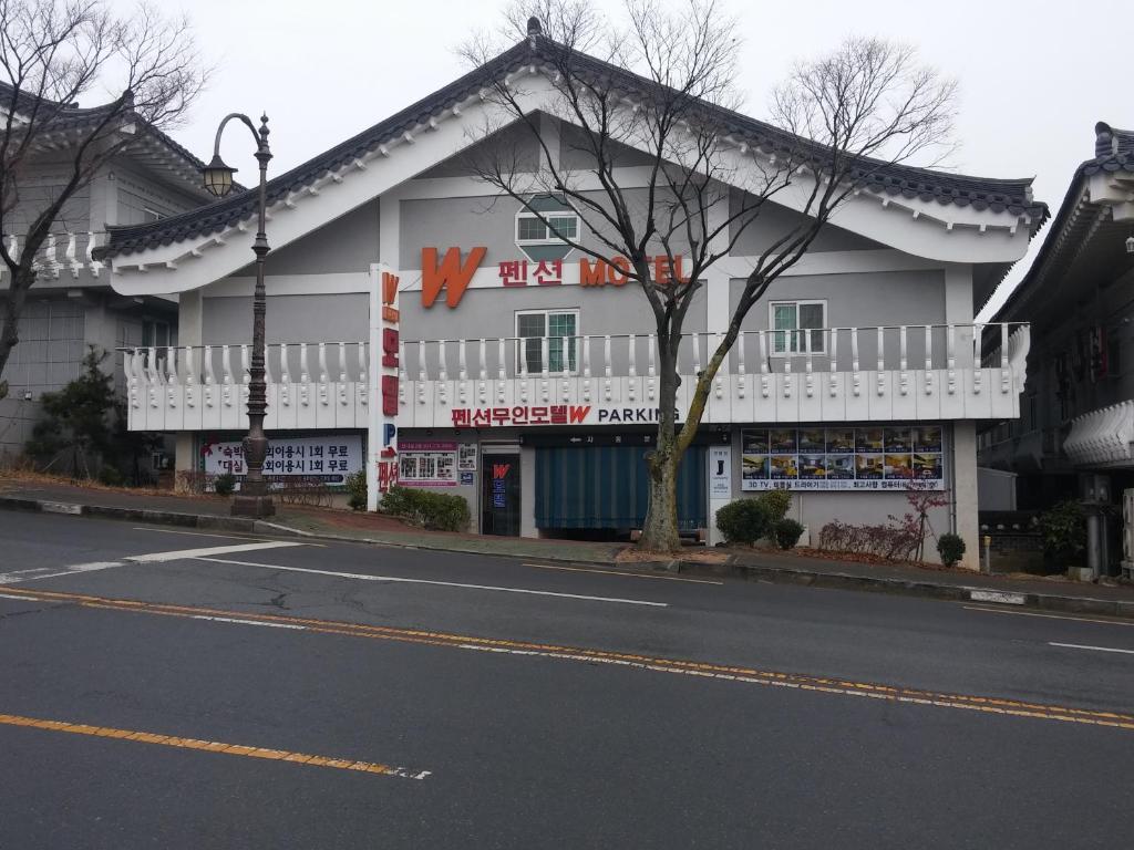 a building with a sign on the side of a street at Gyeongju bulgooksa W Drive-in Motel in Gyeongju